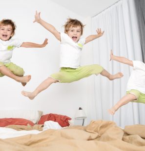 Cheerful,Little,Boy,Jumping,On,Bed,At,Home.,Lot,Of